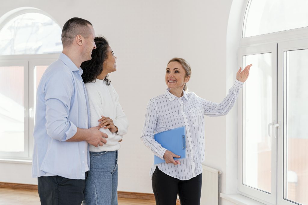 Realtor showing an empty house to a young couple