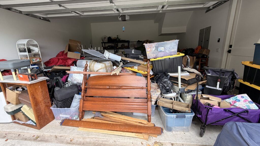 Cluttered garage full of boxes and furniture before a KD Clutter declutter project