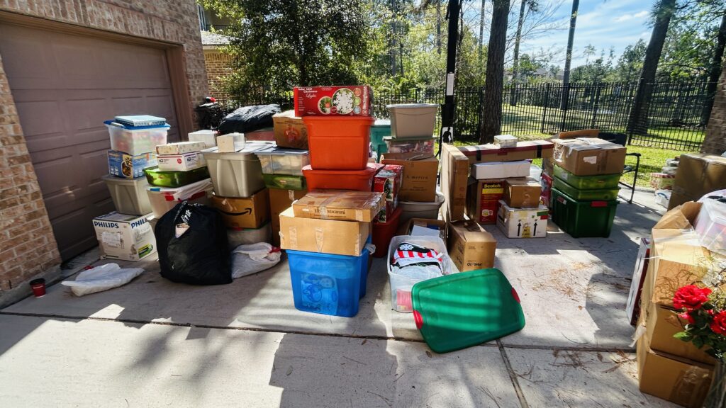 Help someone declutter an aging parent's home: a lifetime of belongings sorted on the driveway during a downsizing in The Woodlands, TX