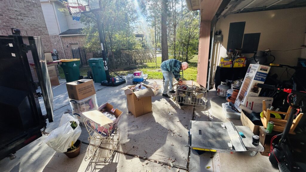 garage and driveway full of boxes during a decluttering session, an example of the clutter and trauma connection