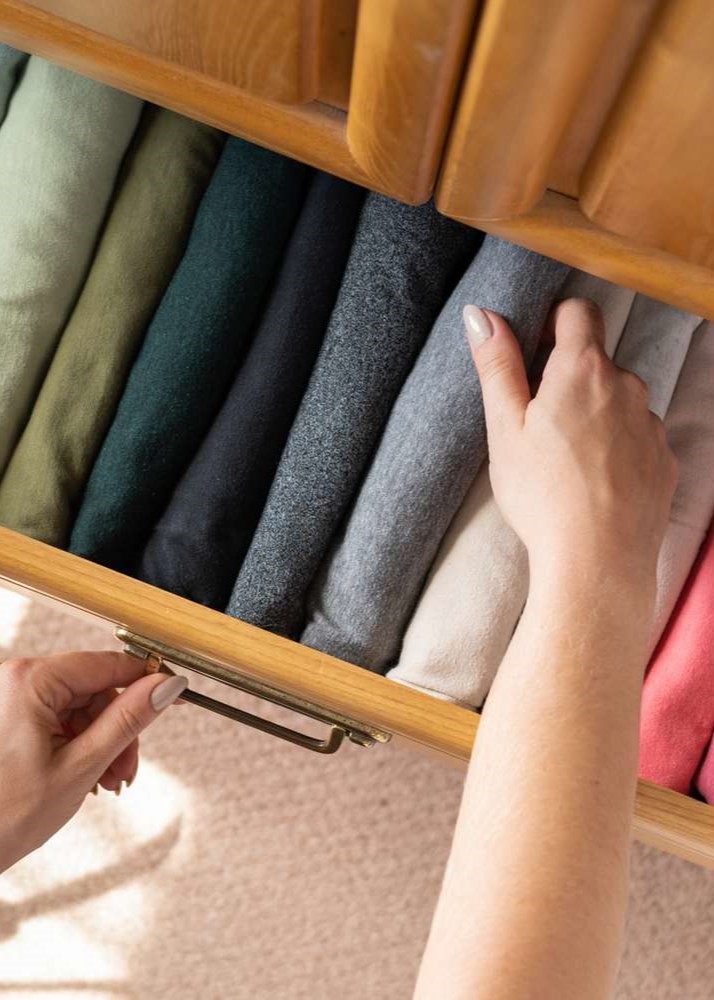 Neatly folded clothes organized in a wooden drawer